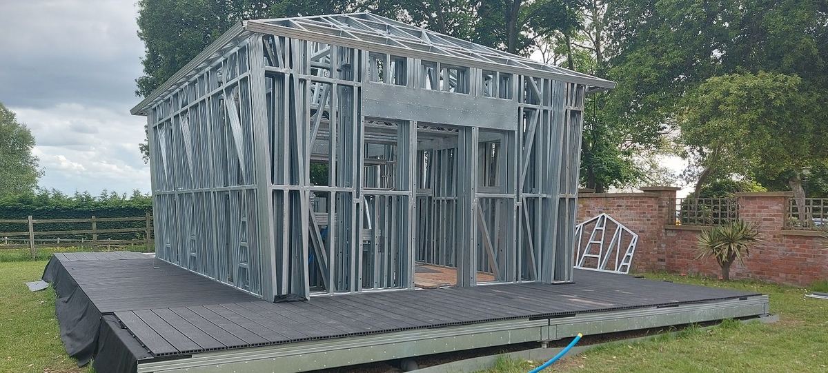The complete steel frame of the garden building on its decking