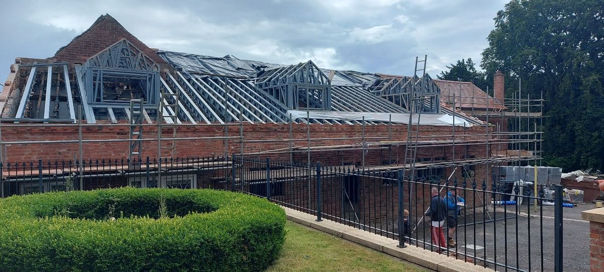 Roof frames in place behind scaffolding, ready to be made watertight